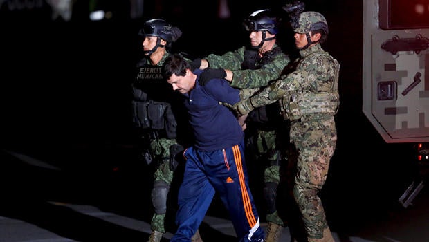 Drug lord Joaquin "El Chapo" Guzman is escorted by soldiers during a presentation in Mexico City Jan. 8, 2016.