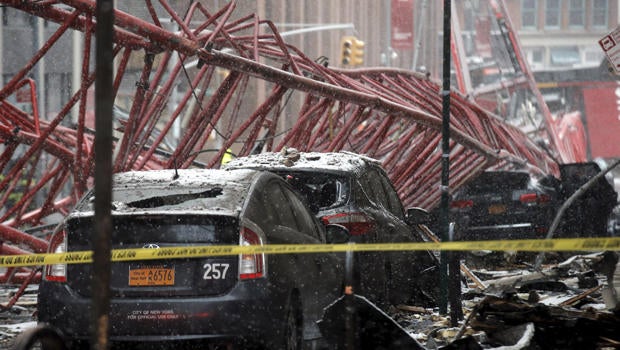 A construction crane is seen on top of cars along a street in Lower Manhattan in New York Feb. 5, 2016.