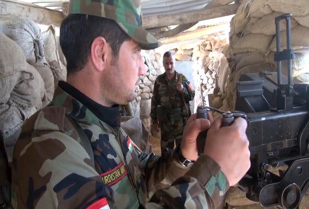 A Kurdish peshmerga fighter mans a machine gun position about 20 miles from the ISIS-held, northern Iraqi city of Mosul