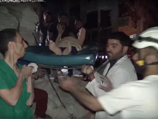 An image taken from video posted online by Syrian activists shows members of the "White Helmets" volunteer rescue service and others removing an injured person from the rubble of the al-Quds hospital in southern Aleppo, which was destroyed by an airstrike