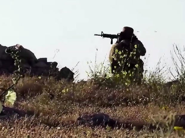 An image taken from video posted online by ISIS purportedly shows one of the group's militants firing on a Kurdish Peshermga position during an intense battle north of Mosul