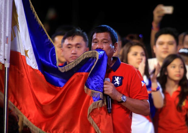 Philippine presidential candidate and Davao city mayor Rodrigo Duterte kisses the Philippine flag during a political campaign rally before the national elections at Rizal park in Manila, Philippines