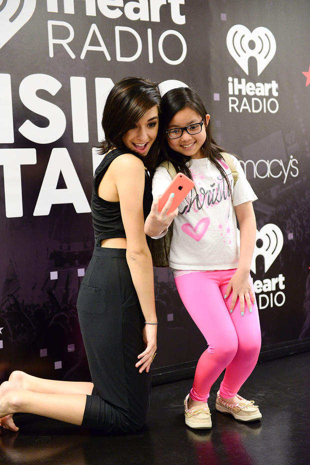Singer Christina Grimmie poses with a fan at Macy's iHeartRadio rising star in-store performance on May 16, 2015, in Whitehall, Pennsylvania. 