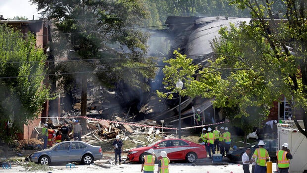 Firefighters look through the debris of a four-story building that was destroyed in a deadly explosion in Silver Spring, Maryland, Aug. 11, 2016.