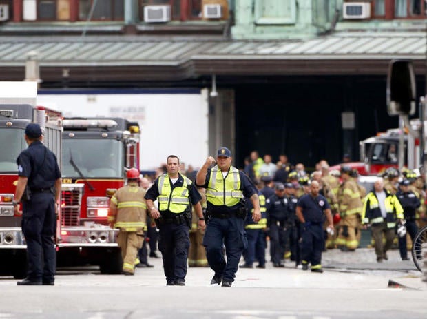 Hoboken police officers look over the scene of a train crash where a New Jersey Transit train derailed and crashed through the station, injuring more than 100 people, in Hoboken, New Jersey, Sept. 29, 2016.