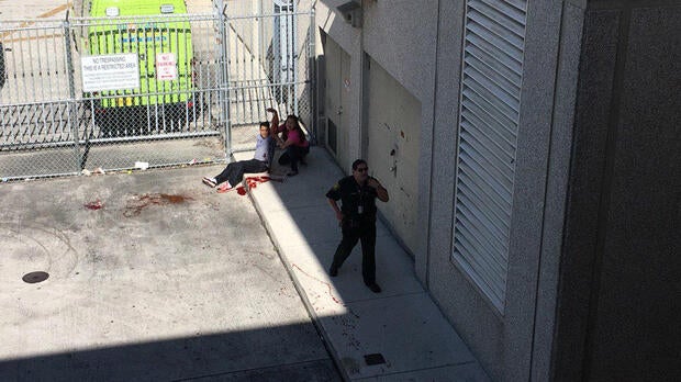 A man with a bleeding wound sits on a curb during a shooting at Fort Lauderdale-Hollywood International Airport in Fort Lauderdale, Florida, on Jan. 6, 2017.