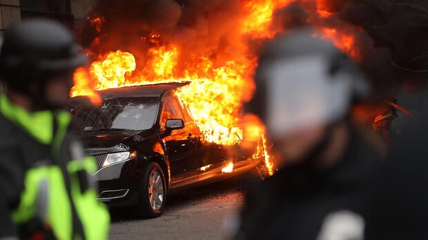 Police and demonstrators clash in downtown Washington after a limo was set on fire following the inauguration of President Trump on Jan. 20, 2017, in Washington.