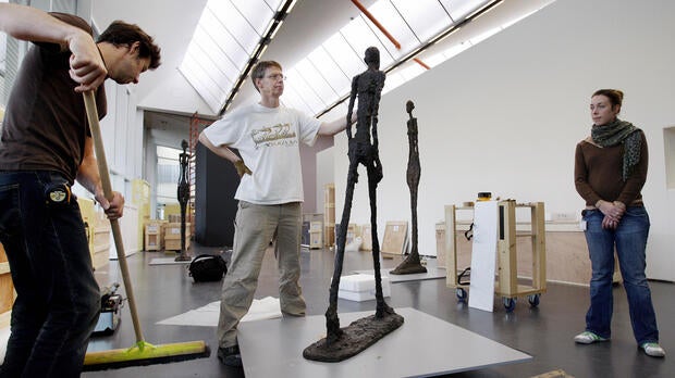 Employees at the Kunsthal museum in Rotterdam, Netherlands, adjust the sculpture “Walking Man” by Swiss artist Alberto Giacometti on Oct. 15, 2008.