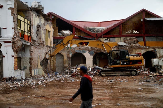Resident walks near debris and destroyed houses after an earthquake in Juchitan