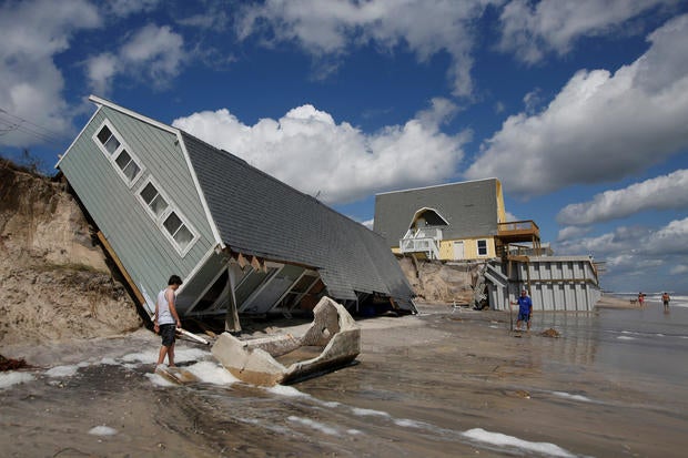 Local residents look at a collapsed coastal house after Hurricane Irma passed the area in Vilano Beach