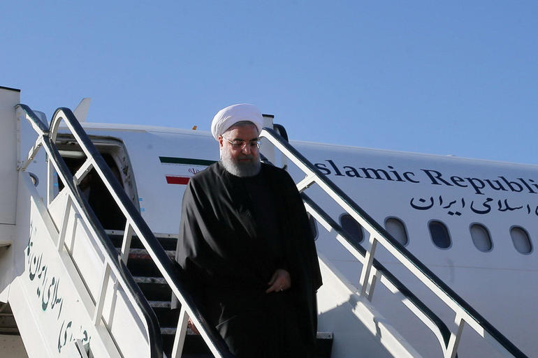 Iranian President Hbadan Rouhani walks down aircraft steps as he arrives at Kermanshah that was hit by a powerful earthquake 