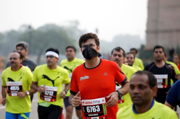 A runner wearing a face mask takes part in the Airtel Delhi Half Marathon in New Delhi