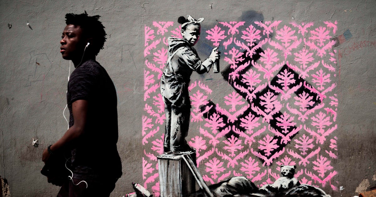 Street artist Banksy paints Paris with murals of migrants ...