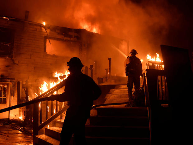 Santa Barbara County firefighters battle flames at a home at the site of a wildfire in Goleta 