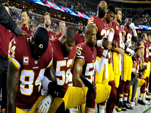 Washington Redskins tight end Niles Paul (84), linebacker Ryan Anderson (52) and linebacker Chris Carter (55) kneel with teammates during the playing of the national anthem before a game against the Oakland Raiders at FedEx Field in Landover, Maryland, on 