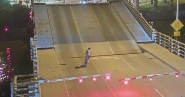 Woman rides bike onto bridge as it opens, falls through crack CBS News