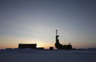 The sun sets behind an oil drilling rig in Prudhoe Bay, Alaska 