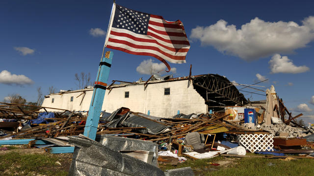 A U.S. flag flies in front of a building damaged by Hurricane Michael in Panama City, Florida, Oct. 11, 2018. 