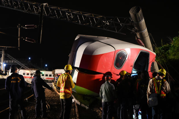 Rescuers search an overturned train in Yilan 