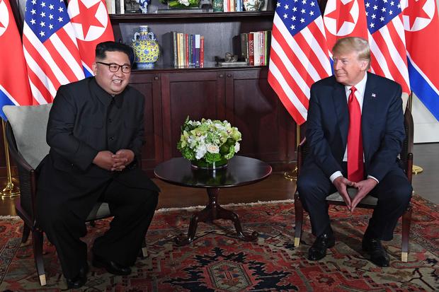President Trump sits next to Kim Jong Un 