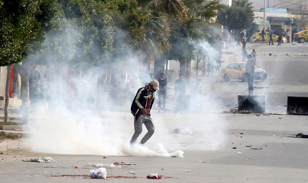 Tear gas is seen as protesters clash with riot police attempting to disperse the crowd during demonstrations, in Kasserine 