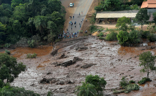 Residents are seen in an area next to a dam owned by Brazilian miner Vale SA that burst 