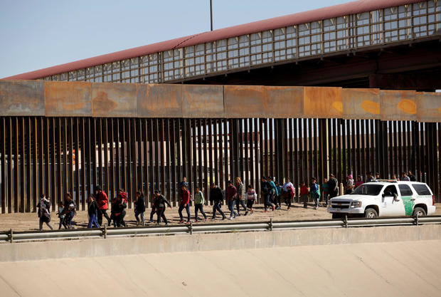 Migrants are escorted by U.S. Customs and Border Protection (CBP) officials after crossing illegally into the United States to request asylum, in El Paso, Texas, U.S., in this picture taken from Ciudad Juarez 