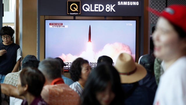 People watch a TV showing a file picture of a North Korean missile for a news report on North Korea firing short-range ballistic missiles, in Seoul 