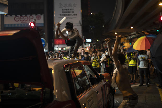Protesters destroy a taxi in Hong Kong on Sunday, September 29, 2019. FELIPE DANA / AP