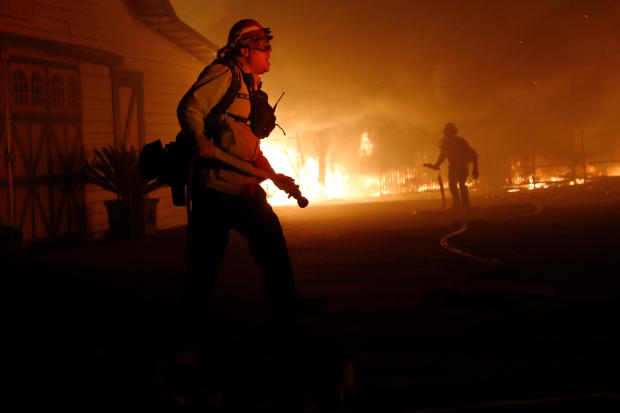 A firefighter gives orders as he battles the wind-driven Kincade Fire in Windsor, California, October 27, 2019. 