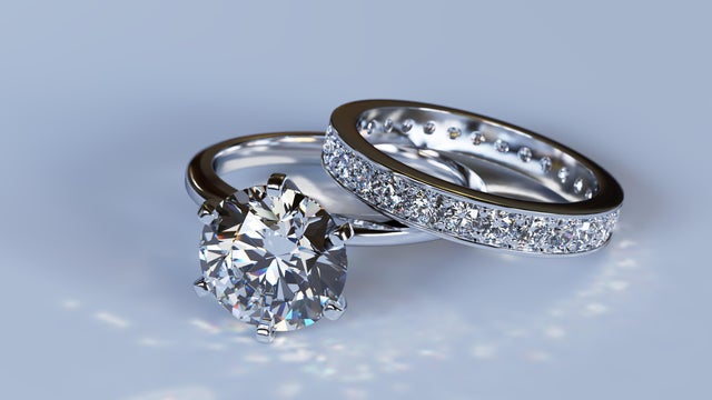 Diamond engagement ring, wedding ring on blue glossy background