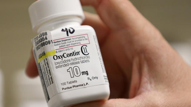 A pharmacist holds a bottle OxyContin made by Purdue Pharma at a pharmacy in Provo, Utah 