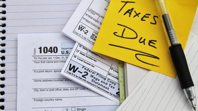 Tax return forms and wage statements with note Taxes Due.