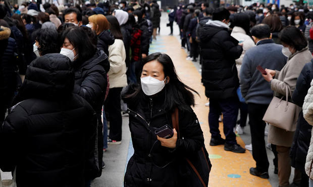 People wearing masks after the coronavirus outbreak wait in a line to buy masks in front of a department store in Seoul 
