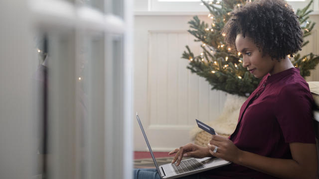Woman online shopping on laptop at Christmas 