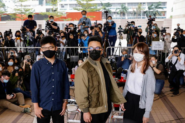 Pro-democracy activists Ivan Lam, Joshua Wong and Agnes Chow arrive at the West Kowloon Magistrates' Courts to face charges related to illegal assembly stemming from 2019, in Hong Kong 