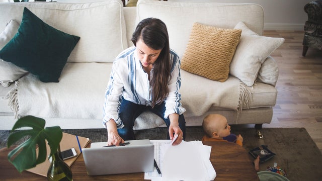 High angle view of female entrepreneur concentrating on work while daughter playing at home office