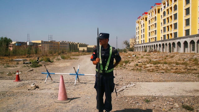 FILE PHOTO: A Chinese police officer takes his position by the road near what is officially called a vocational education centre in Yining