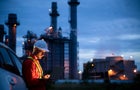 Petrochemical engineers work slowly and heavily with smart tablets in the oil and gas industry at night. 