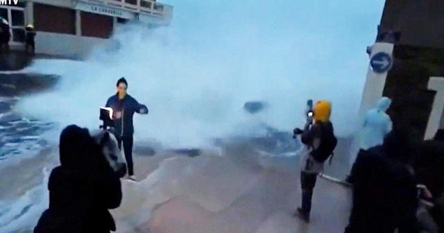 Reporter knocked down by giant wave