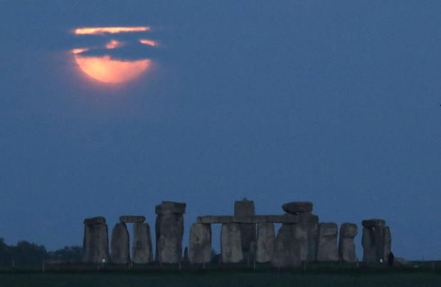 The full moon, known as the "Super Flower Moon", is seen behind Stonehenge stone circle near Amesbury 
