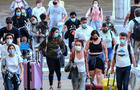 Travelers wearing protective face masks arrive at Orlando 