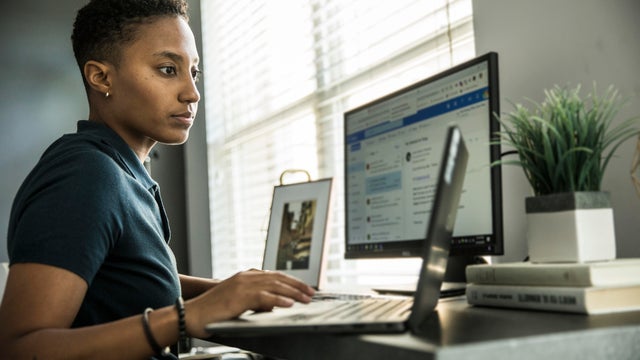 Young woman working on desktop computer at home