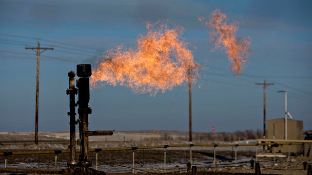 Gas flare burns against blue sky 
