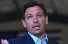 Florida Governor, Ron DeSantis listens to another speaker at 