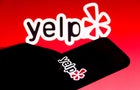 In this photo illustration a Yelp logo is seen on a 