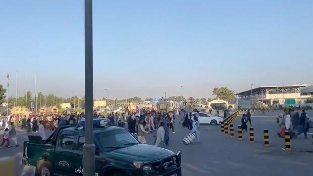 A horde of people run towards the Kabul Airport Terminal, after Taliban insurgents took control of the presidential palace in Kabul 