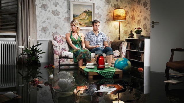 young couple in sofa in a flooded room 