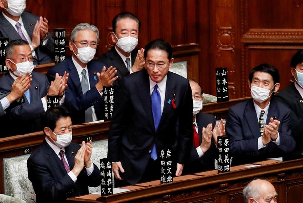 Japan's newly-elected Prime Minister Fumio Kishida is applauded after being chosen as the new prime minister, at the Lower House of Parliament in Tokyo