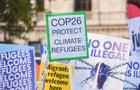 A placard reading "COP26 protect climate refugees" 